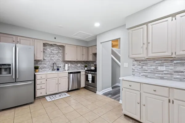 a kitchen with white cabinets and stainless steel appliances