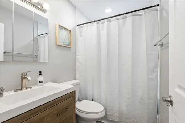 a bathroom with a sink a toilet and shower curtain