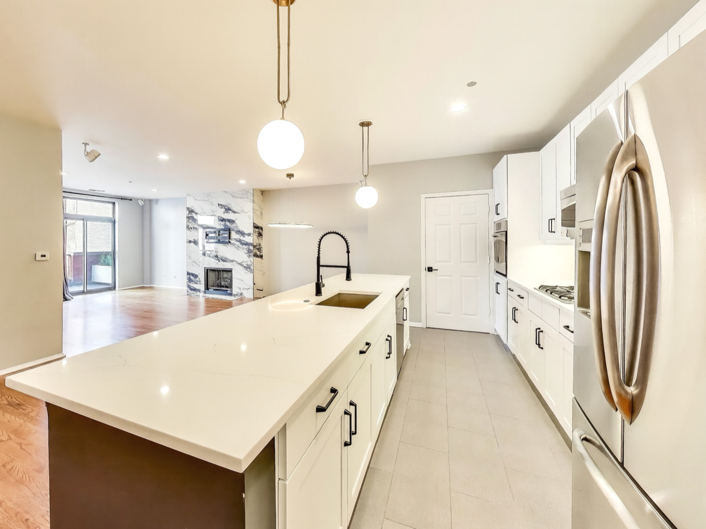 33 West Huron Street, Unit 412 Chicago, IL 60654 - Photo 15 of 33 a large white kitchen with a large window a sink and stainless steel appliances
