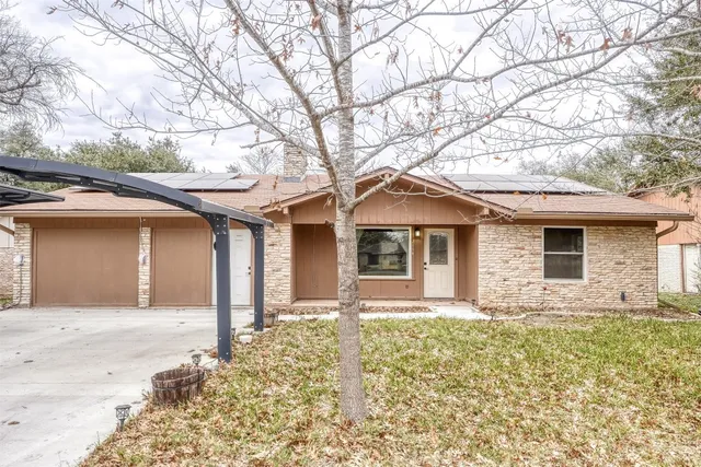 front view of a house with a large tree