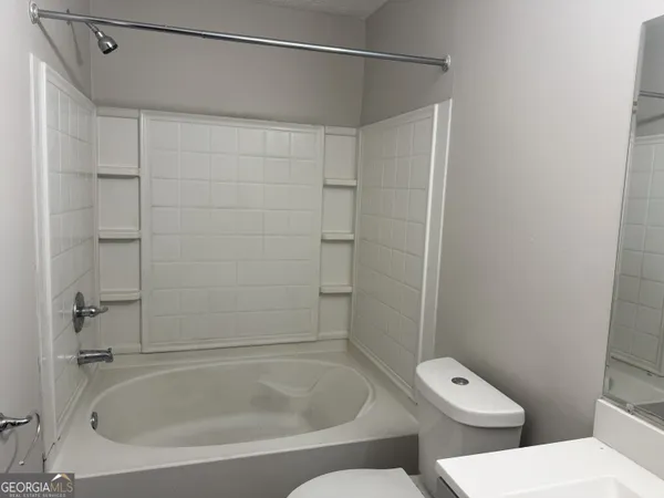 a bathroom with a tub and toilet