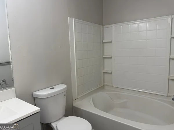 a white toilet sitting next to a bath tub