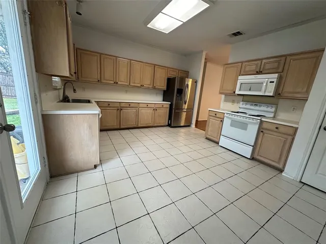 a kitchen with a sink a stove top oven and cabinetry