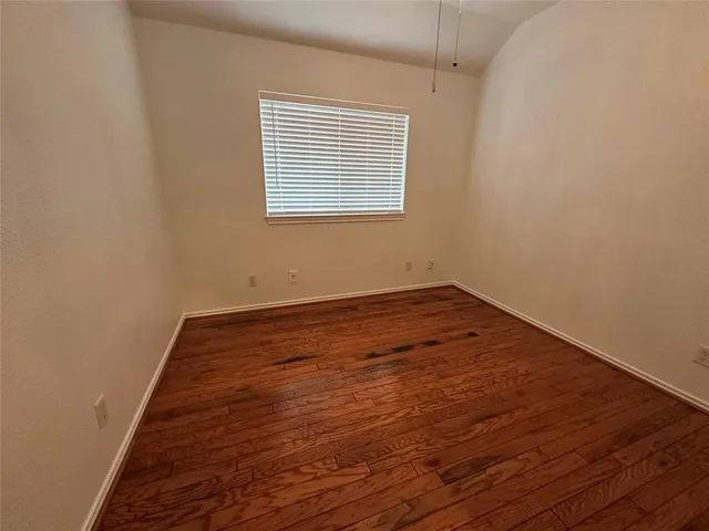 a view of a room with wooden floor and window