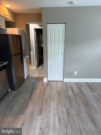 a view of a kitchen with wooden floor and a refrigerator