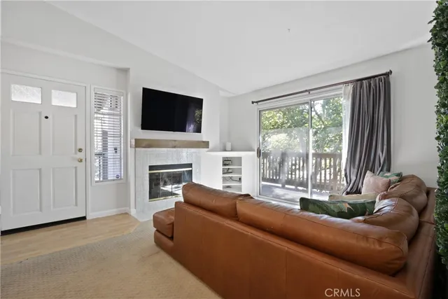 a living room with furniture a flat screen tv and a fireplace