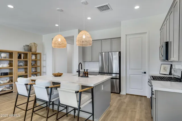 a kitchen with stainless steel appliances kitchen island granite countertop a sink a refrigerator and a stove