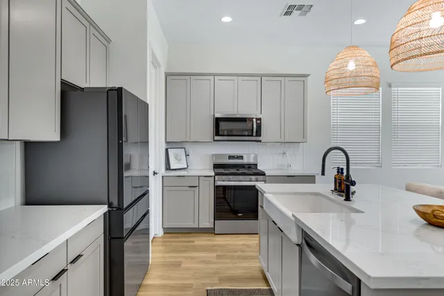 a kitchen with stainless steel appliances granite countertop a sink stove and refrigerator