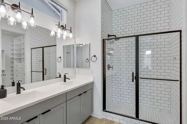 a bathroom with a double vanity sink mirror and shower