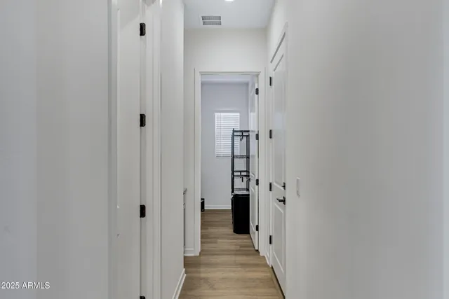 a view of a hallway with closet and wooden floor