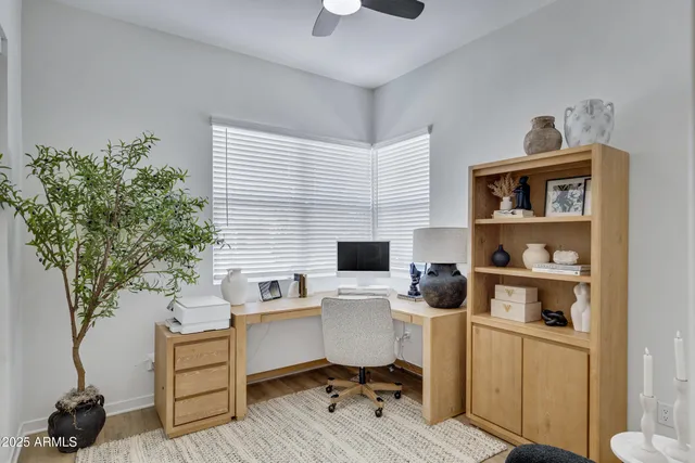 a view of a workspace with furniture and a window