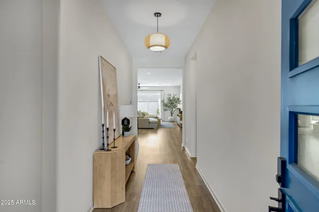 a view of a hallway with a livingroom and a chandelier