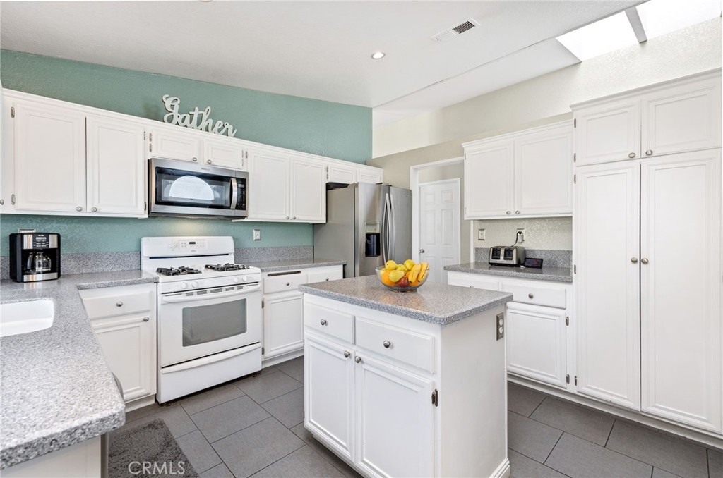 3147 Wimbledon Way Hemet, CA 92545 - Photo 19 of 41 a kitchen with white cabinets and white appliances