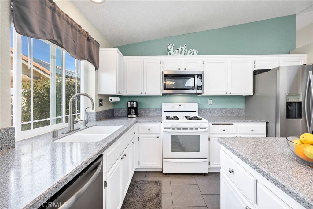 3147 Wimbledon Way Hemet, CA 92545 - Photo 20 of 41 a kitchen with a sink a stove and cabinets