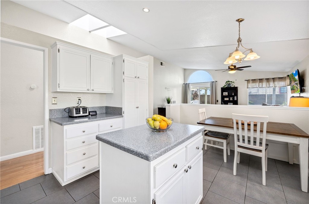 3147 Wimbledon Way Hemet, CA 92545 - Photo 21 of 41 a view of kitchen island with stainless steel appliances granite countertop a sink a stove a dining table and chairs