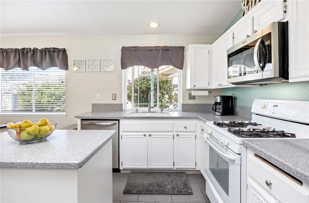 3147 Wimbledon Way Hemet, CA 92545 - Photo 22 of 41 a kitchen with stainless steel appliances granite countertop a stove a sink and a microwave
