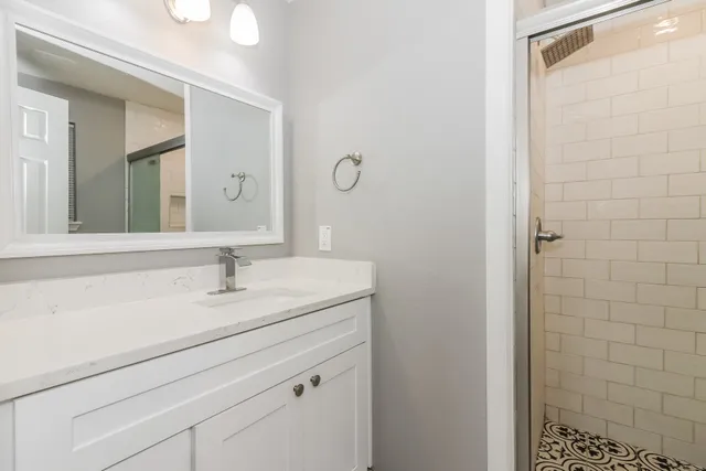 a bathroom with a granite countertop sink and a mirror