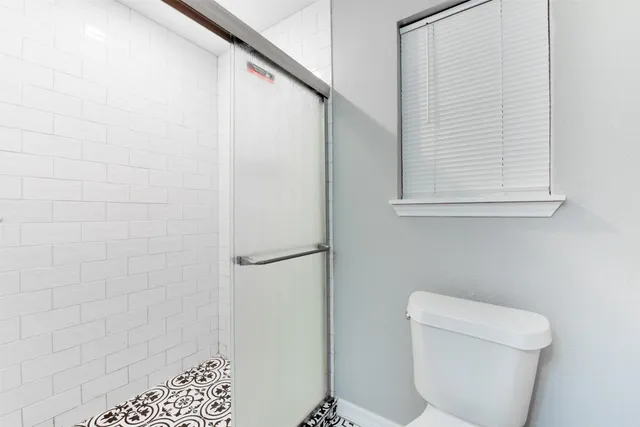 a bathroom with a toilet and a shower