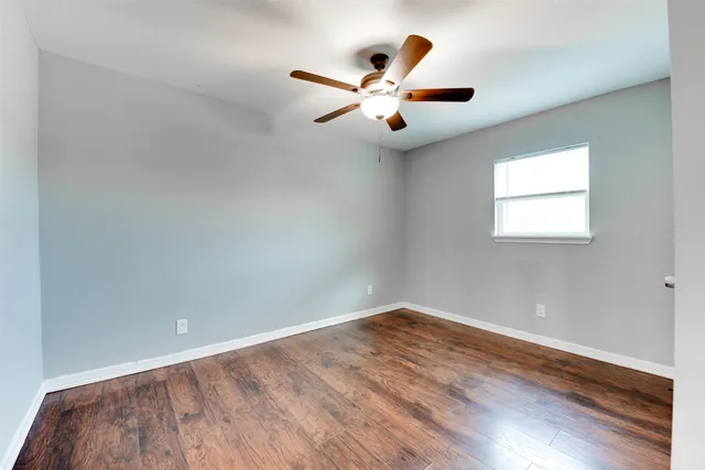 wooden floor in an empty room with a window