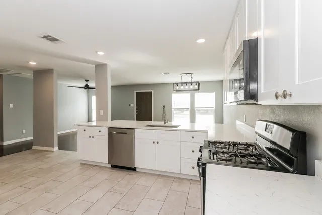 a large kitchen with stainless steel appliances granite countertop a stove and a sink