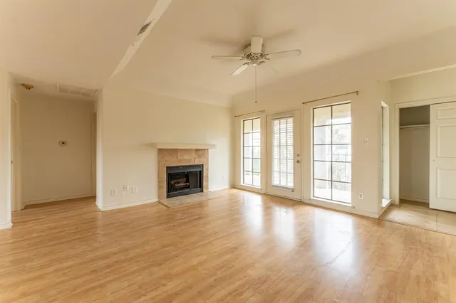 wooden floor fireplace and windows in an empty room