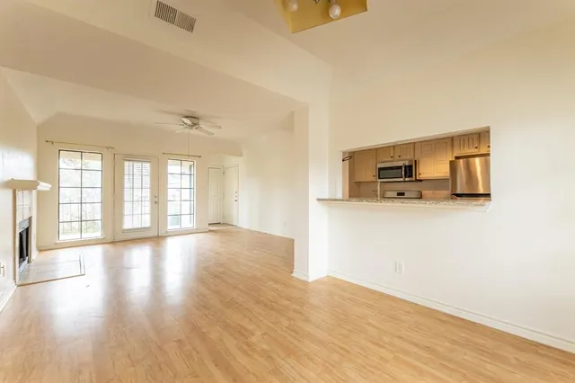 a view of a kitchen with wooden floor and electronic appliances