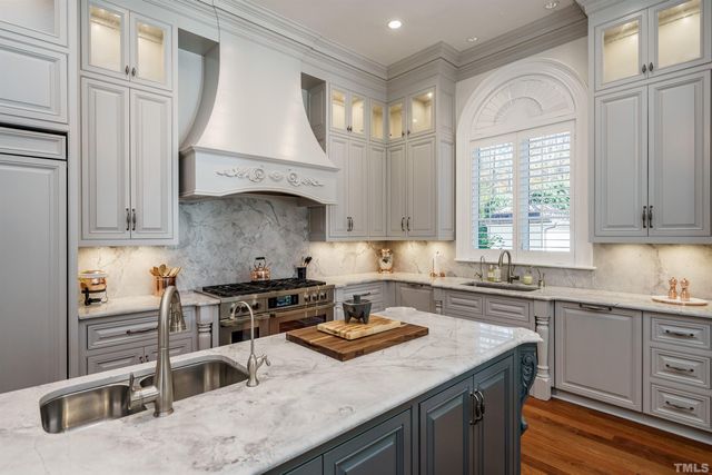 a kitchen with granite countertop a sink a stove and cabinets