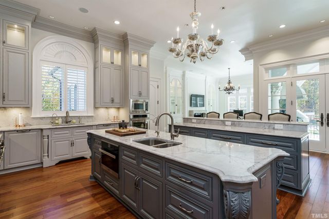 a bathroom with a granite countertop sink a large mirror and a wooden floor