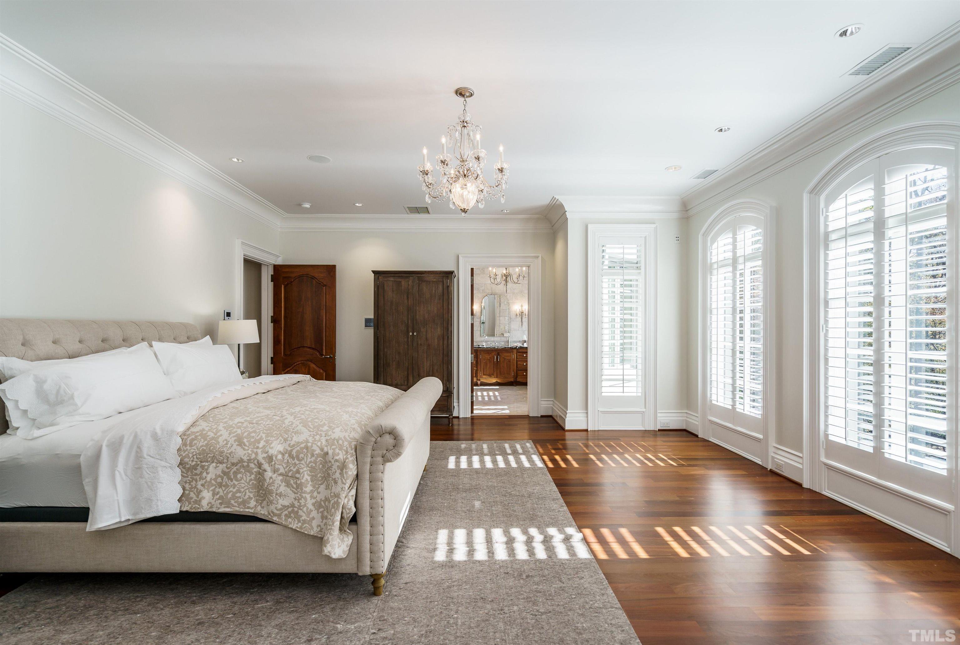 1624 Morning Mountain Road Raleigh, NC 27614 - Photo 19 of 30 a spacious bedroom with a large bed and a chandelier