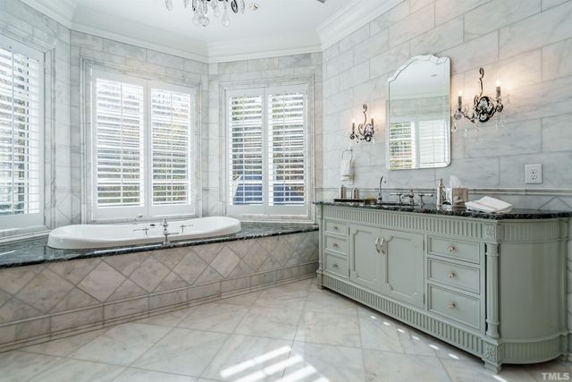 a bathroom with a granite countertop sink and a large mirror