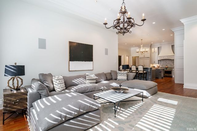 a living room with furniture a chandelier and a flat screen tv