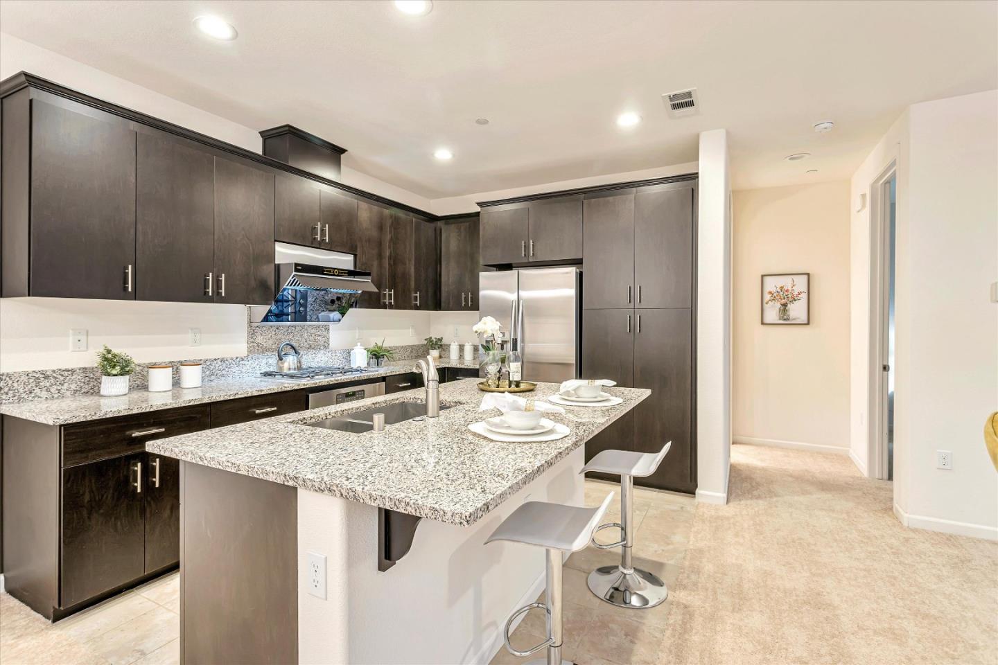 1886 Trento Loop Milpitas, CA 95035 - Photo 6 of 43 a kitchen with kitchen island granite countertop a sink cabinets and refrigerator