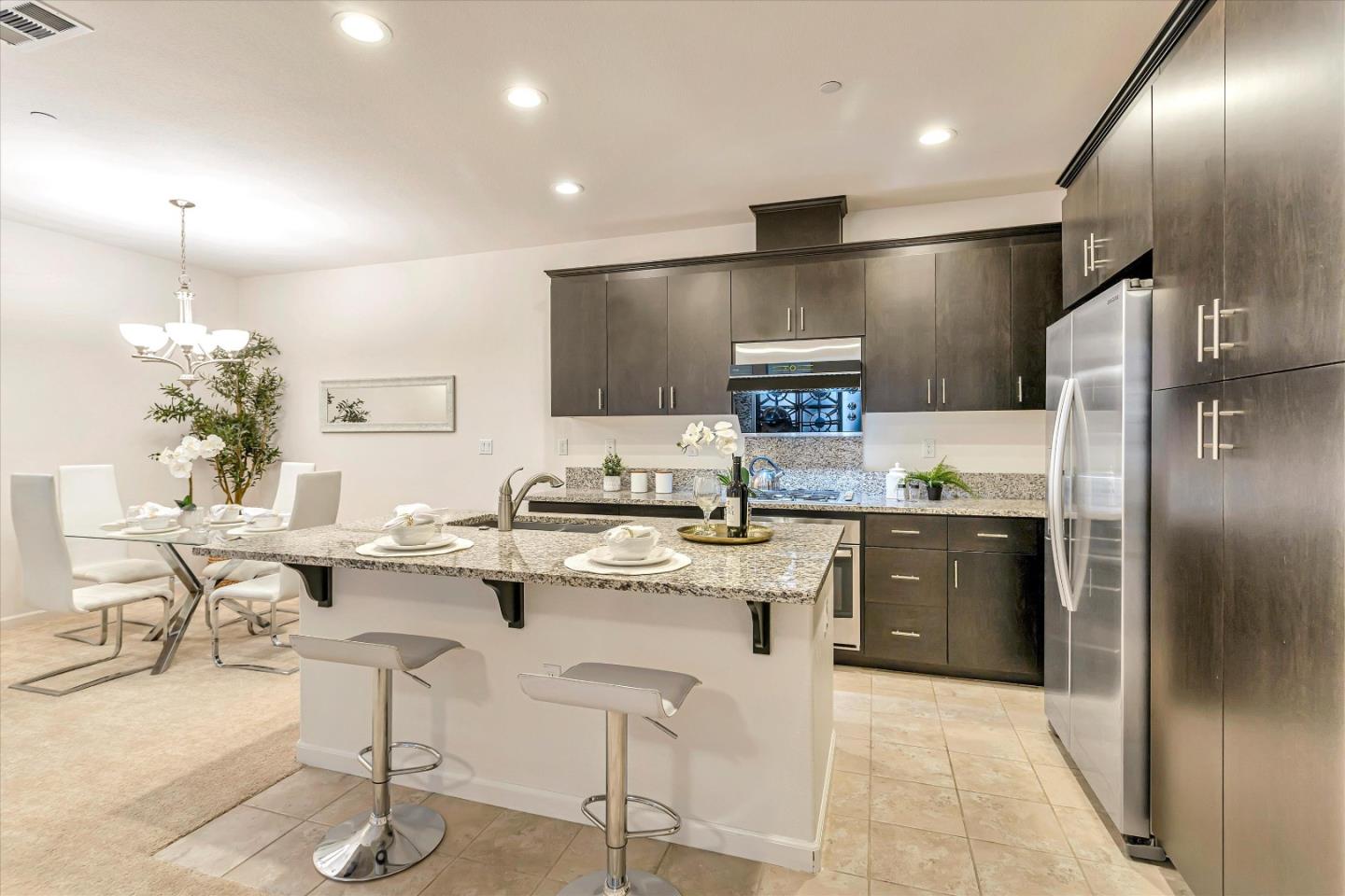 1886 Trento Loop Milpitas, CA 95035 - Photo 7 of 43 a kitchen with stainless steel appliances kitchen island granite countertop a sink and cabinets