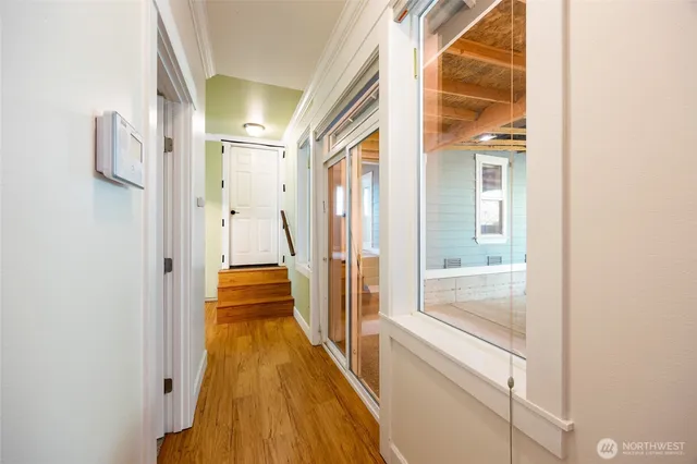 a view of a hallway with wooden floor and staircase