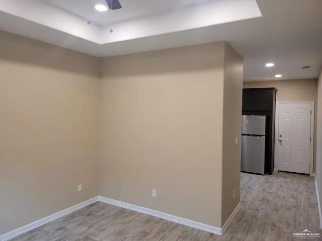 a view of a hallway with wooden floor and closet