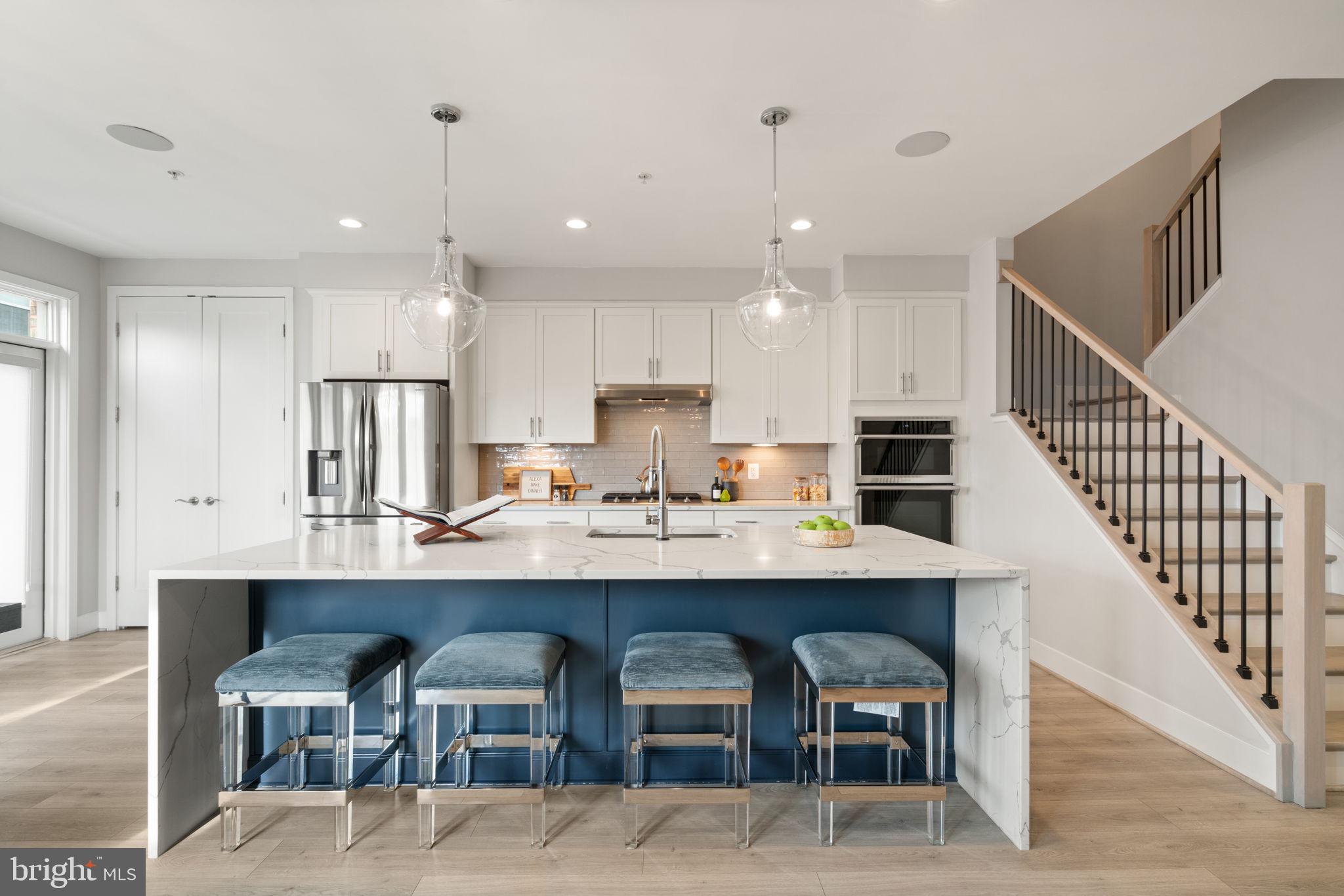 3006 Eskridge Road Fairfax, VA 22031 - Photo 33 of 41 a kitchen with stainless steel appliances kitchen island granite countertop a table chairs in it and wooden floors