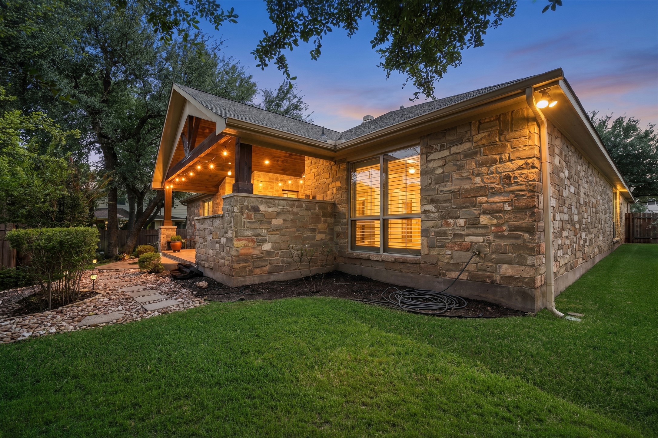 402 Ridgetop Bend Cedar Park, TX 78613 - Photo 37 of 40 A stone exterior coordinates beautifully with the covered rear porch and grassy yard.