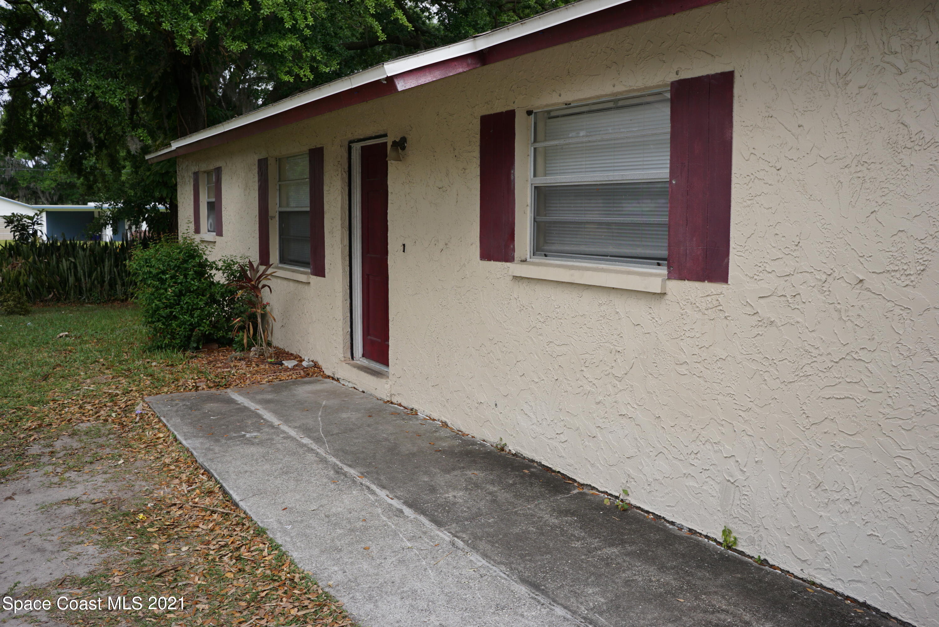 1052 Bernice Road Rockledge, FL 32955 - Photo 2 of 39 a couple of potted plants in front of door