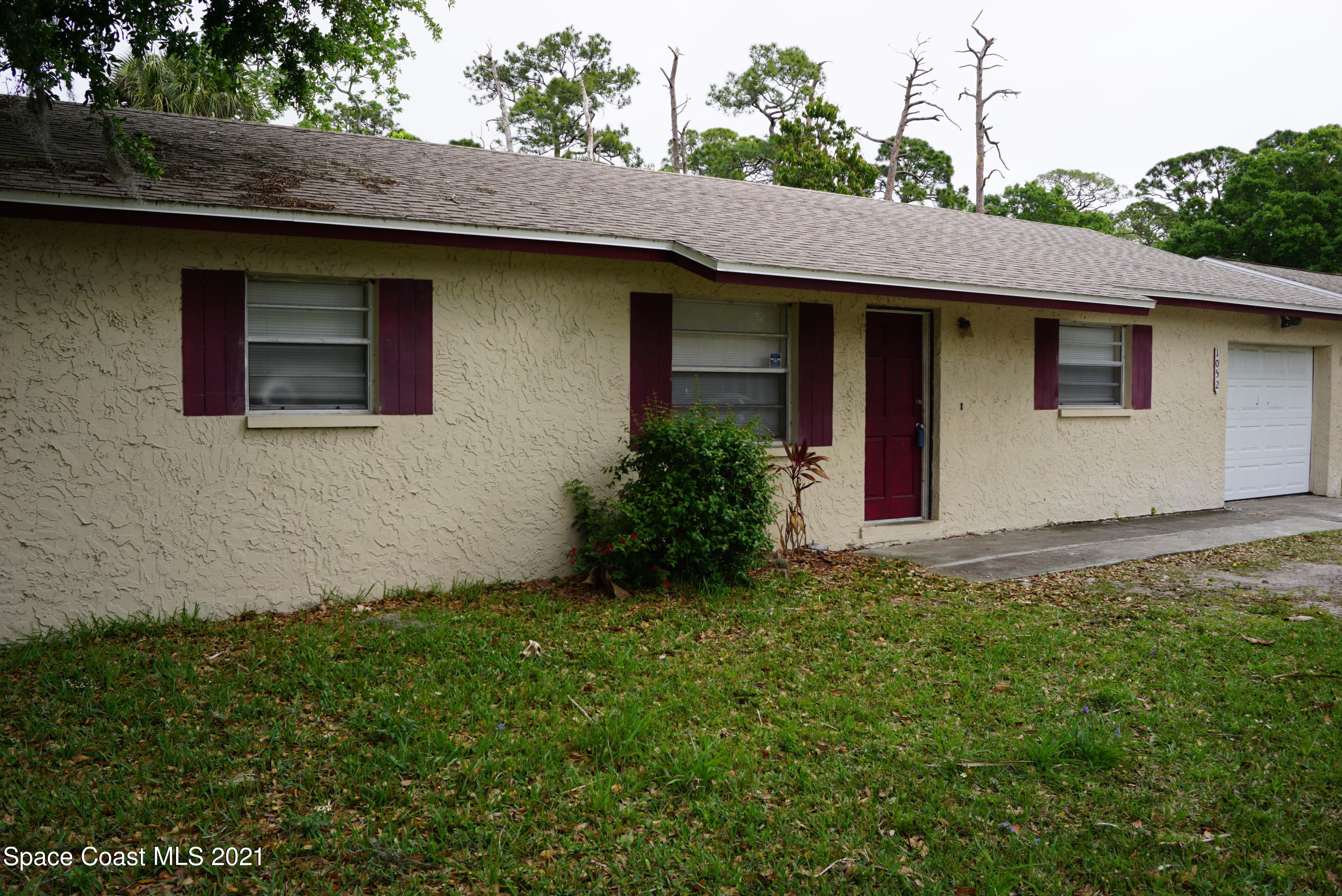 1052 Bernice Road Rockledge, FL 32955 - Photo 3 of 39 a view of a house with a yard plants and large tree