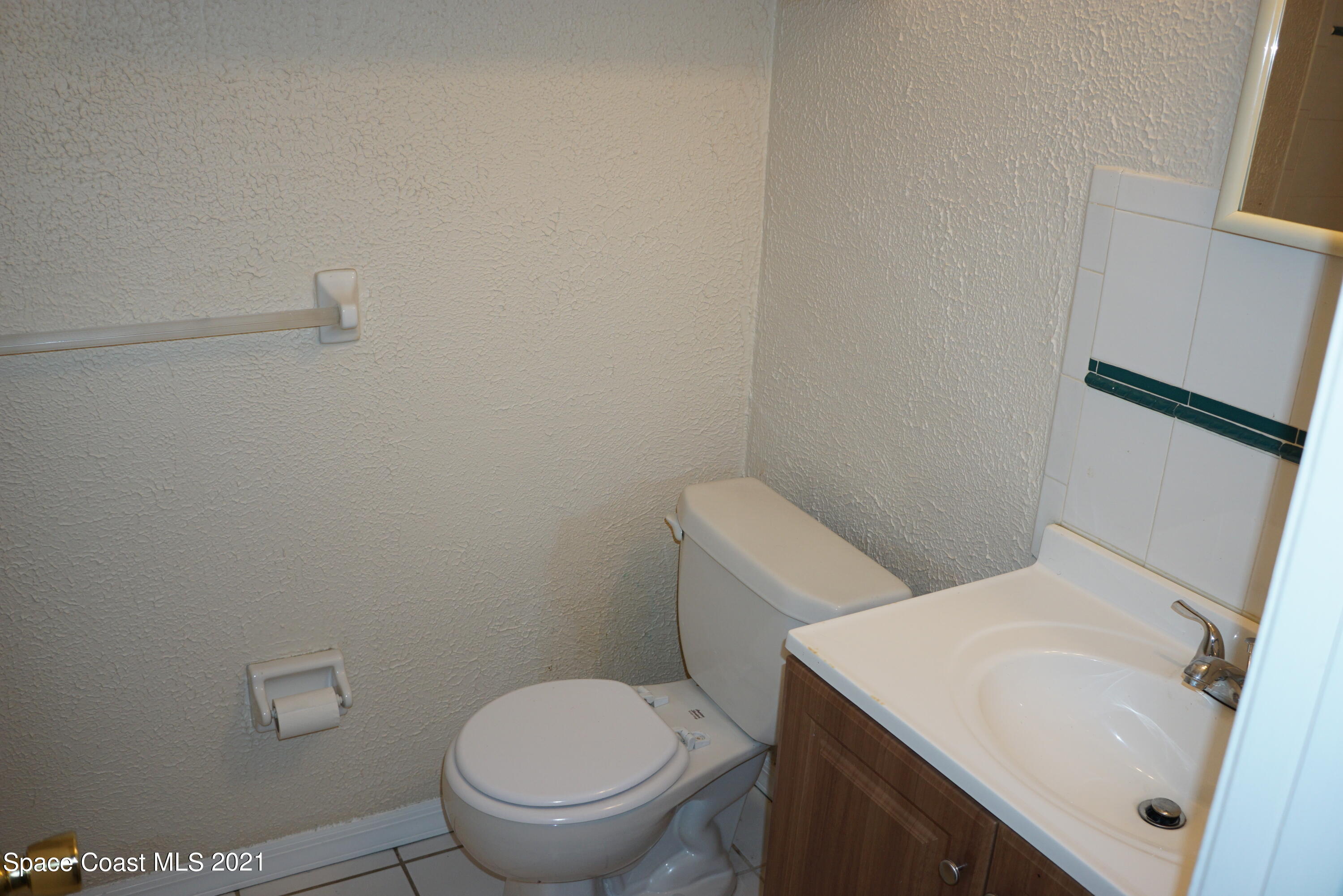 1052 Bernice Road Rockledge, FL 32955 - Photo 23 of 39 a white toilet sitting next to a bathroom sink