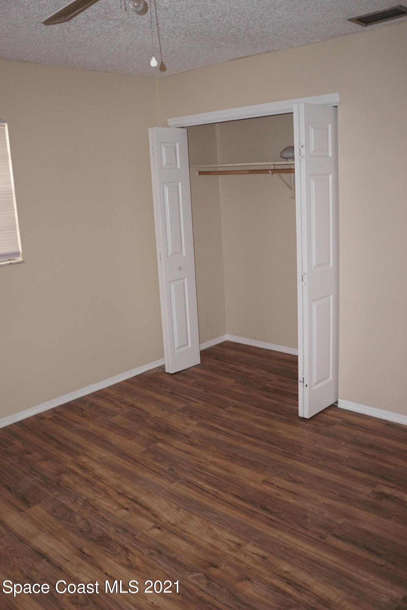 1052 Bernice Road Rockledge, FL 32955 - Photo 27 of 39 an empty room with wooden floor and closet