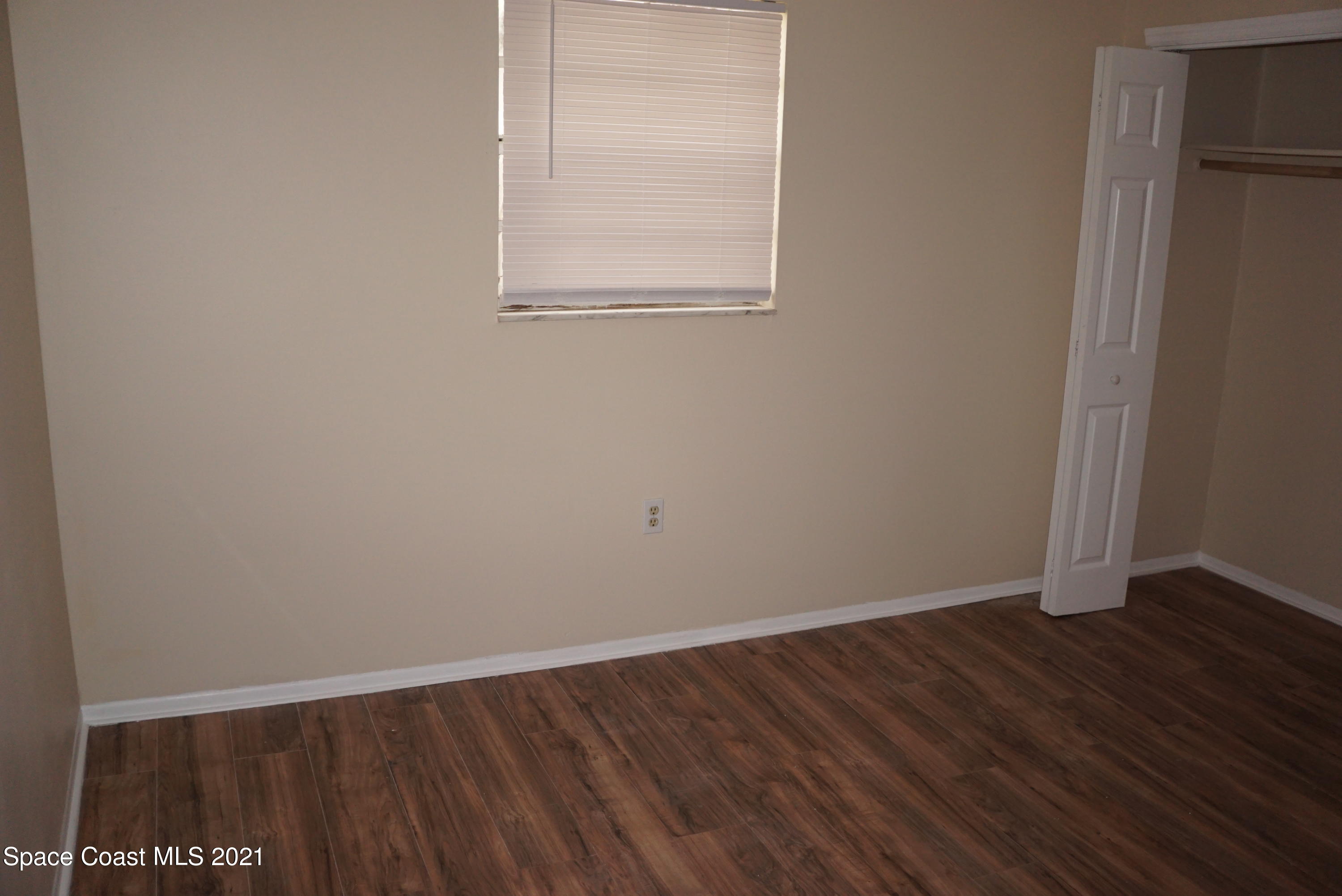 1052 Bernice Road Rockledge, FL 32955 - Photo 28 of 39 a view of an empty room with wooden floor and a window