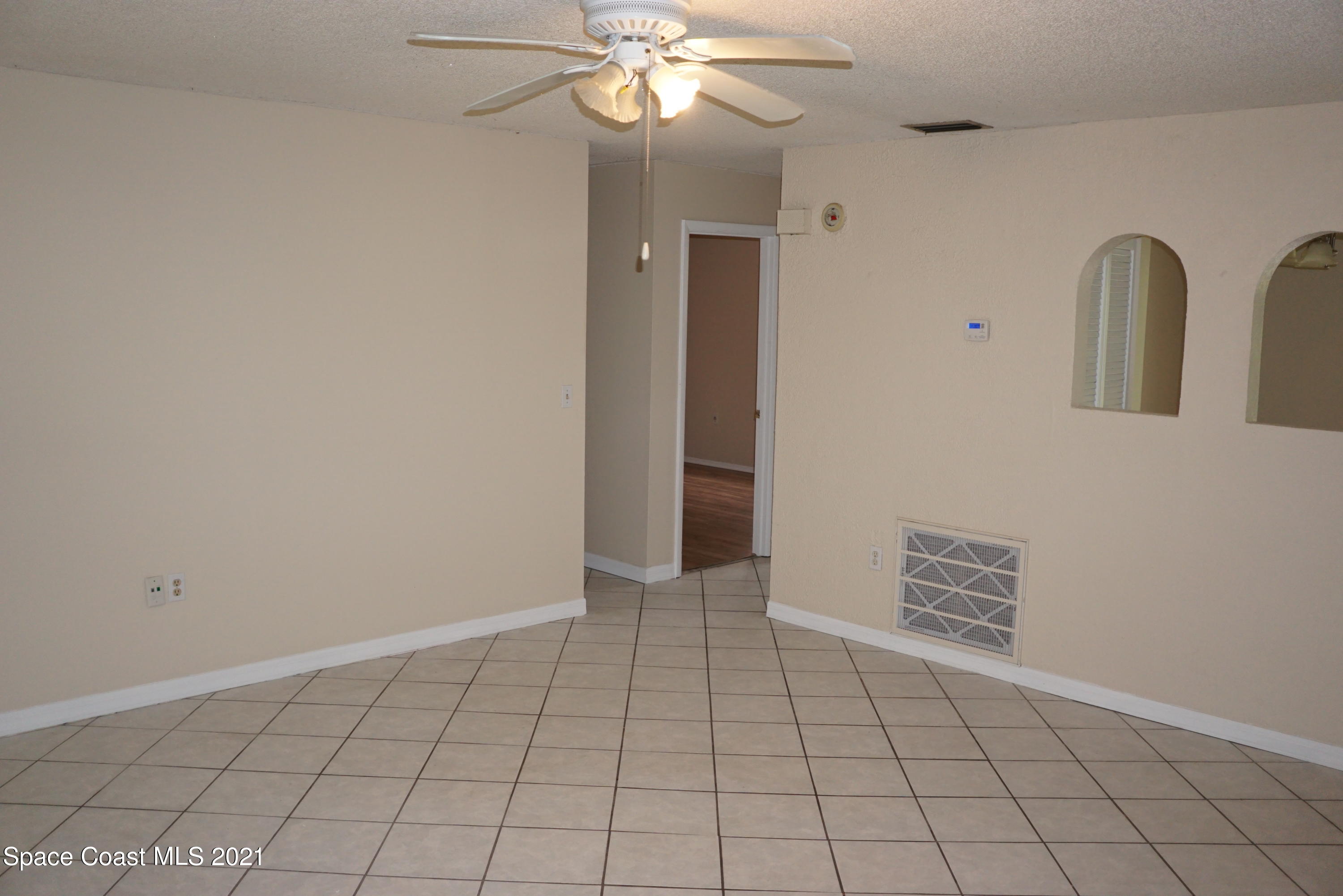 1052 Bernice Road Rockledge, FL 32955 - Photo 9 of 39 a view of an empty room with window and chandelier fan