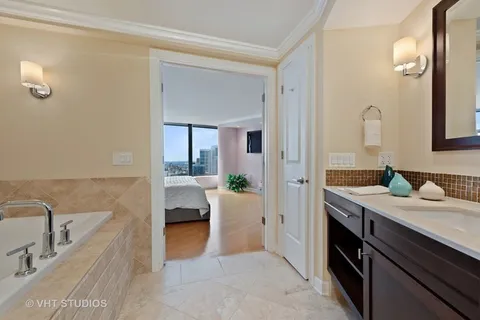 a en suite bathroom with a granite countertop sink and mirror