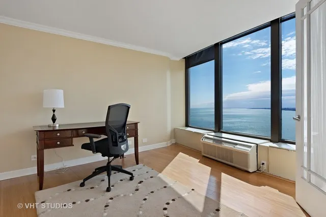 a view of a workspace with furniture and a window