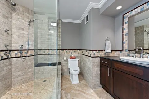 a bathroom with a sink a toilet a mirror and shower