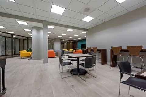 a living room with furniture a table tennis and a flat screen tv