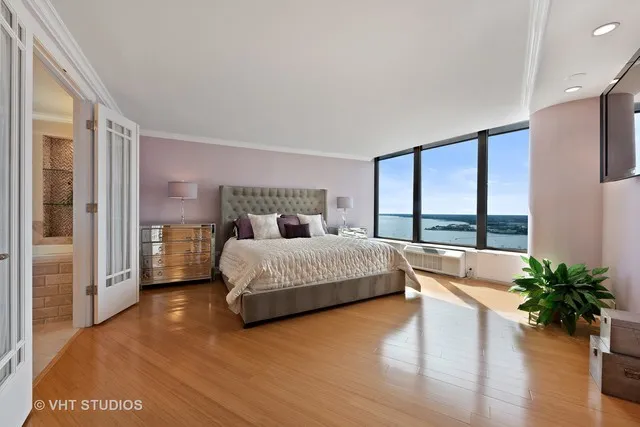a bedroom with a large bed and a potted plant