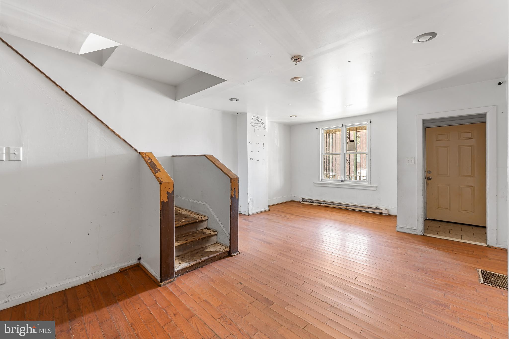 5215 Chester Avenue Philadelphia, PA 19143 - Photo 3 of 19 a view of an empty room with wooden floor and stairs