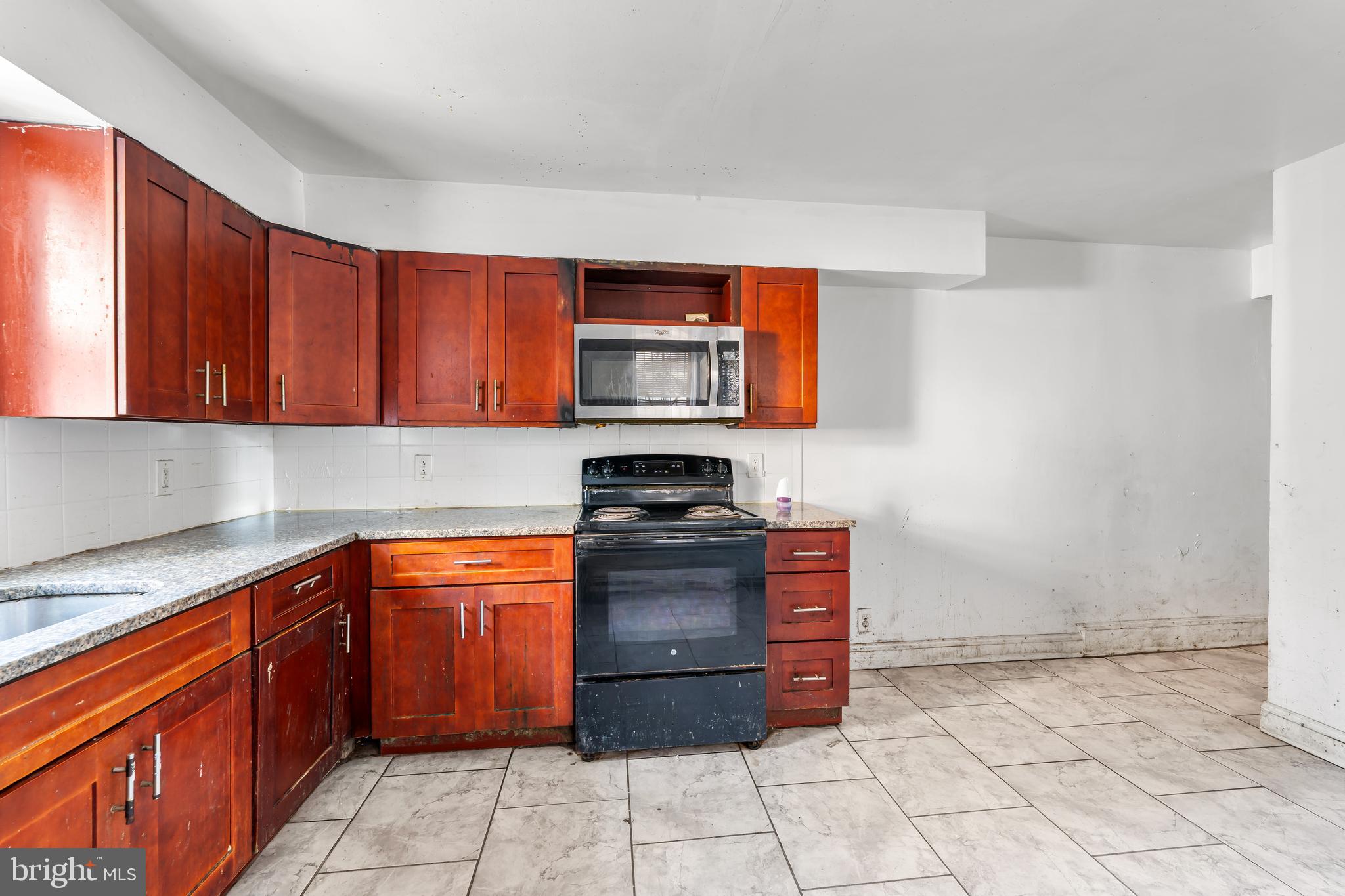 5215 Chester Avenue Philadelphia, PA 19143 - Photo 6 of 19 a kitchen with stainless steel appliances granite countertop a stove a sink and a microwave